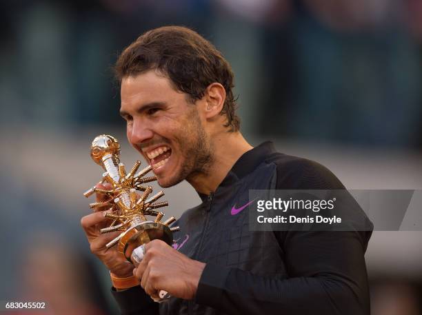 Rafael Nadal of Spain celebrates with the trophy after beating Dominic Thiem of Austria in the men's final at La Caja Magica on May 14, 2017 in...