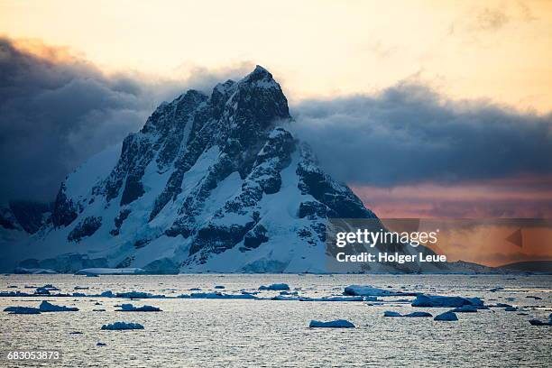 ice floes and snow-covered mountain at sunset - antarctic peninsula stock-fotos und bilder