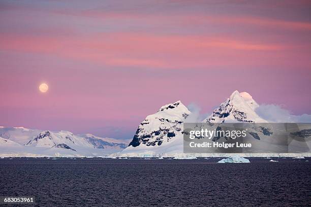 moonrise over snow-covered mountains at dusk - antarctica sunset stock pictures, royalty-free photos & images