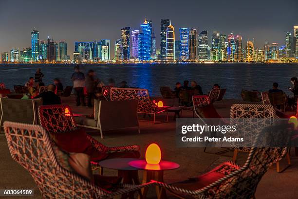 outdoor seating with view of doha skyline - tour of qatar fotografías e imágenes de stock