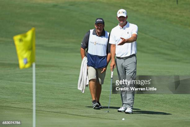 Lucas Glover of the United States talks with his caddie Don Cooper on the 11th green during the final round of THE PLAYERS Championship at the...