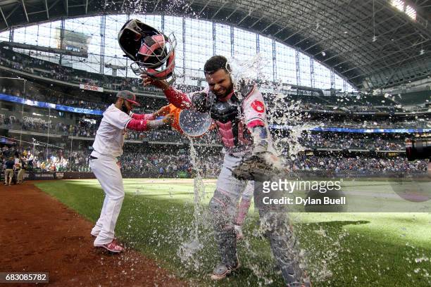 Jonathan Villar and Hernan Perez of the Milwaukee Brewers dump water on Manny Pina after defeating the New York Mets 11-9 at Miller Park on May 14,...
