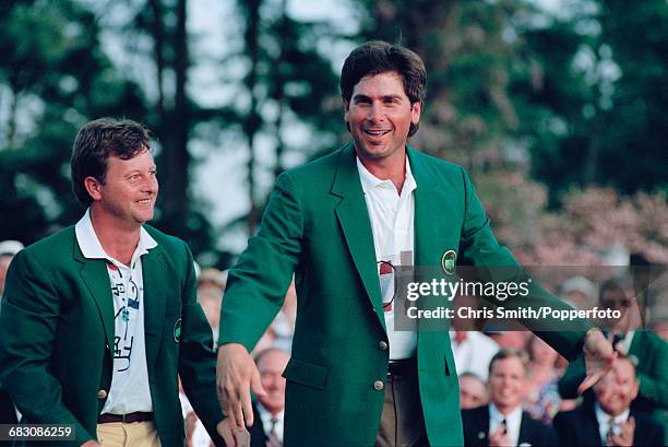 American golfer Fred Couples is presented with his green jacket by the previous year's winner, Welsh golfer Ian Woosnam at the green jacket...