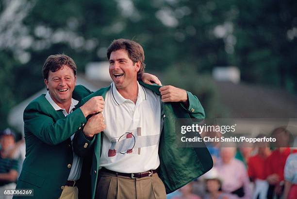 American golfer Fred Couples is presented with his green jacket by the previous year's winner, Welsh golfer Ian Woosnam at the green jacket...
