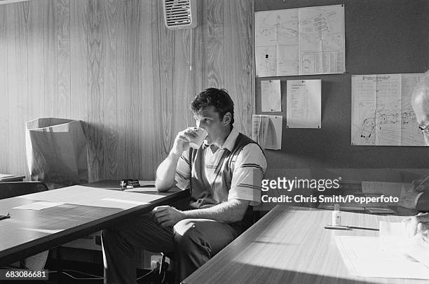 English golfer Nick Faldo pictured taking a drink as he signs his card in the clubhouse after finishing in first place to win the 1990 Open...