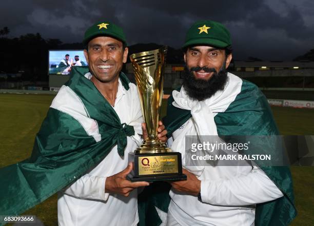 Retiring Pakistan cricket team members Younis Khan and captain Misbah-ul-Haq celebrate with the series trophy after winning the final test match and...