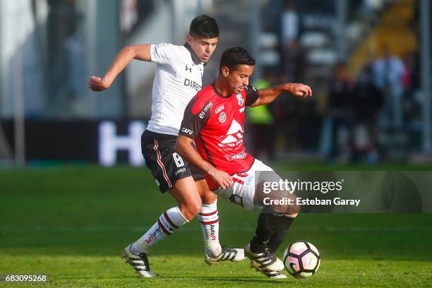 Esteban Pavez of Colo Colo struggles for the ball with Gabriel Sandoval of Antofagasta during a match between Colo Colo and Deportes Antofagasta as...