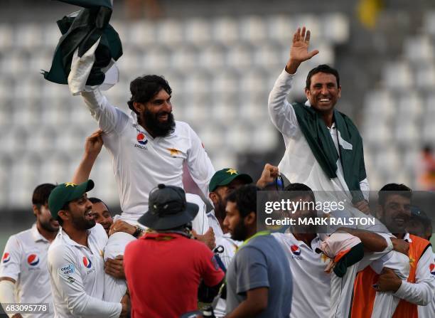 Retiring Pakistan cricket team members captain Misbah-ul-Haq and Younis Khan are carried by teammates as they celebrate after winning the final test...