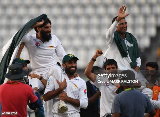 Retiring Pakistan cricket team members captain Misbah-ul-Haq and Younis Khan are carried by teammates as they celebrate after winning the final test...