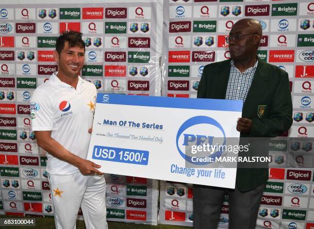 Man of the Series Yasir Shah receives his award from Dominica official Vincent Elwin after Pakistan won the final test match and the series 2-1...