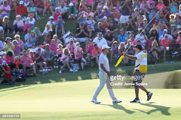 Si Woo Kim of South Korea celebrates with his caddie Mark Cavens after finishing 10 under to win during the final round of THE PLAYERS Championship...