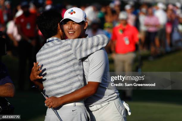 Si Woo Kim of South Korea celebrates with his father on the 18th green after finishing 10 under to win during the final round of THE PLAYERS...