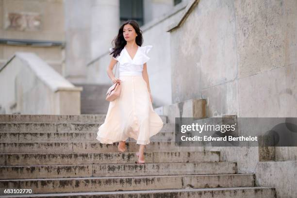 May Berthelot, fashion blogger and Head of Legal at Videdressing.com, wears an Asos white ruffled top, an Asos pleated pink skirt, Louboutin Pigalle...
