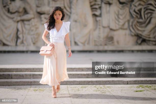 May Berthelot, fashion blogger and Head of Legal at Videdressing.com, wears an Asos white ruffled top, an Asos pleated pink skirt, Louboutin Pigalle...