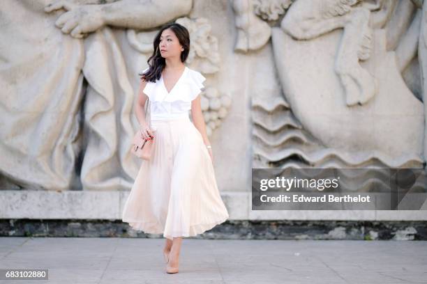 May Berthelot, fashion blogger and Head of Legal at Videdressing.com, wears an Asos white ruffled top, an Asos pleated pink skirt, Louboutin Pigalle...