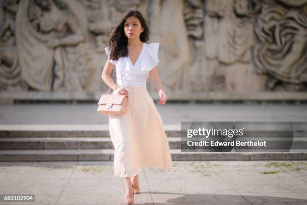 May Berthelot, fashion blogger and Head of Legal at Videdressing.com, wears an Asos white ruffled top, an Asos pleated pink skirt, Louboutin Pigalle...