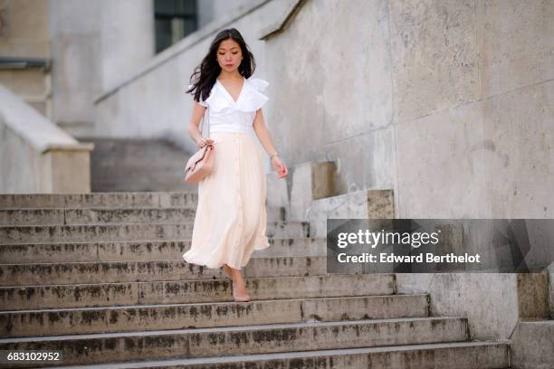 May Berthelot, fashion blogger and Head of Legal at Videdressing.com, wears an Asos white ruffled top, an Asos pleated pink skirt, Louboutin Pigalle...