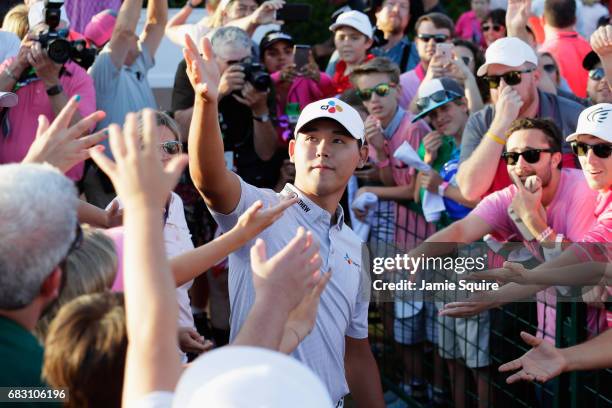 Si Woo Kim of South Korea throws his glove to fans after winning during the final round of THE PLAYERS Championship at the Stadium course at TPC...