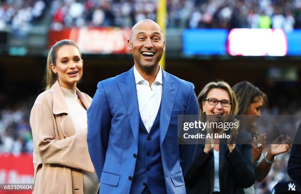 Derek Jeter reacts with his family looking on during the retirement ceremony of his number 2 jersey at Yankee Stadium on May 14, 2017 in New York...