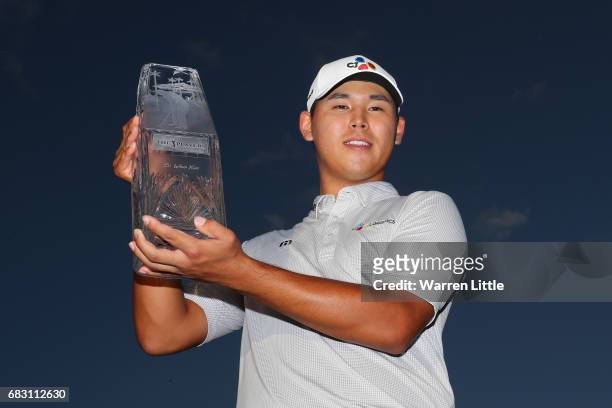 Si Woo Kim of South Korea celebrates with the winner's trophy after the final round of THE PLAYERS Championship at the Stadium course at TPC Sawgrass...