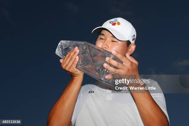 Si Woo Kim of South Korea celebrates with the winner's trophy after the final round of THE PLAYERS Championship at the Stadium course at TPC Sawgrass...