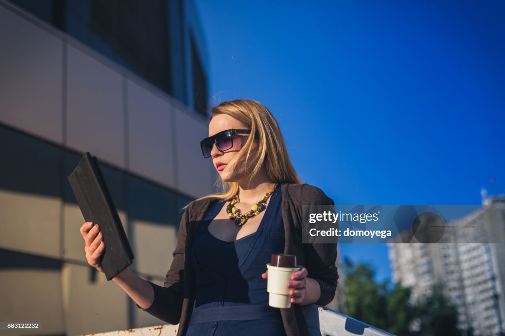 Young businesswoman using a laptop outdoors on a spring day