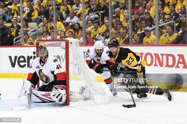 Pittsburgh Penguins center Scott Wilson tires to scores from behind the net on Ottawa Senators goalie Craig Anderson as Ottawa Senators center Zack...