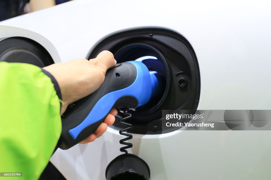 Close view of man do  Power supply for electric car charging at Electric car charging station.