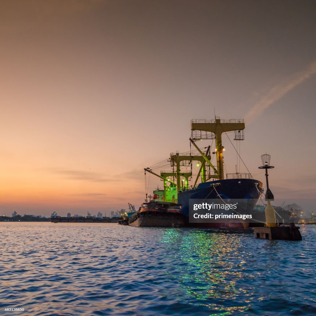 Container Cargo freight ship with working crane bridge in shipyard