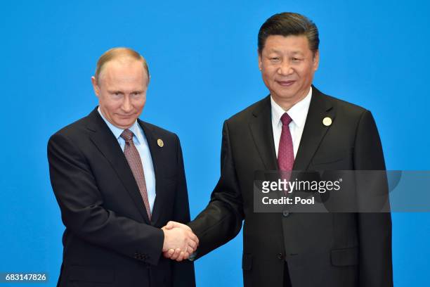 Russian President Vladimir Putin shakes hands with Chinese President Xi Jinping during the welcome ceremony for the Belt and Road Forum, at the...