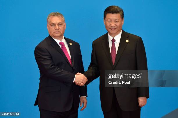 Hungary's Prime Minister Viktor Orban shakes hands with Chinese President Xi Jinping during the welcome ceremony for the Belt and Road Forum, at the...