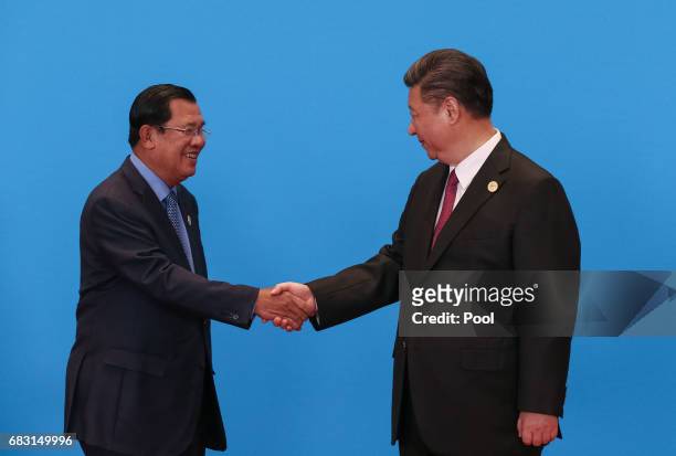 Chinese President Xi Jinping shakes hands with Cambodian Prime Minister Hun Sen as they attend the welcome ceremony at Yanqi Lake during the Belt and...