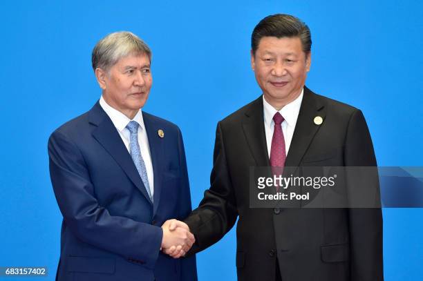 Kyrgyzstan's President Almazbek Sharshenovich Atambayev shakes hands with Chinese President Xi Jinping during the welcome ceremony for the Belt and...