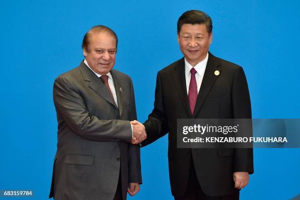 Pakistan's Prime Minister Nawaz Sharif shakes hands with China's President Xi Jinping during the welcome ceremony for the Belt and Road Forum, at the...