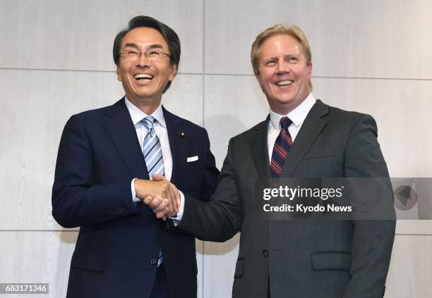 Japanese Economic and Fiscal Policy Minister Nobuteru Ishihara and New Zealand Trade Minister Todd McClay shake hands after their talks in Tokyo on...