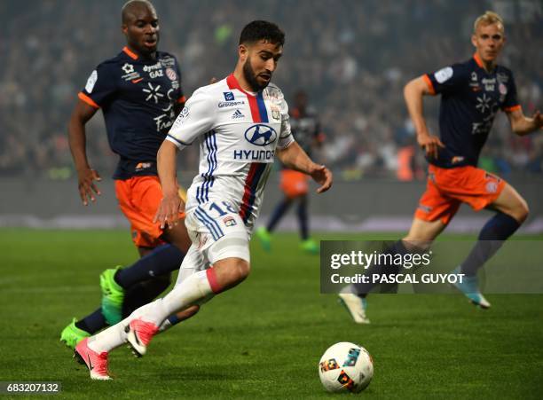 Lyon's French midfielder Nabil Fekir vies with Montpellier's Malian midfielder Yacouba Sylla and Montpellier's Czech defender Lukas Pokorny during...