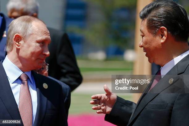 Chinese President Xi Jinping speaks with Russian President Vladimir Putin as delegation heads arrive for a family photo during the Belt and Road...