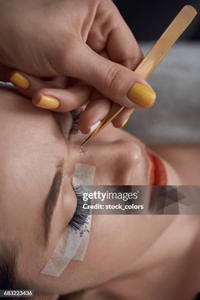 applying false eyelashes in spa salon - eyelash extensions stock pictures, royalty-free photos & images