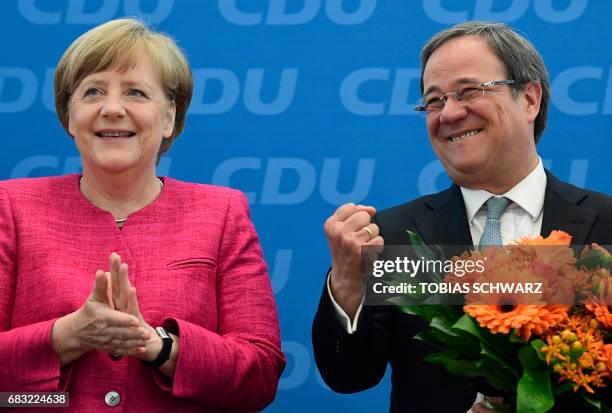 German Chancellor Angela Merkel applauds Armin Laschet, top candidate of their conservative Chrisitan Democratic Union party for regional elections...