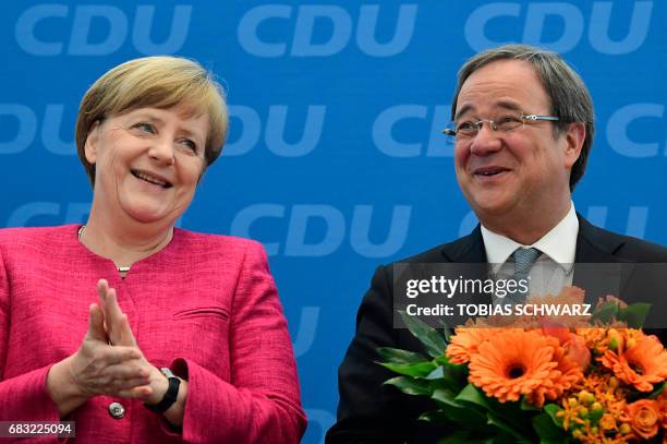 German Chancellor Angela Merkel applauds Armin Laschet, top candidate of their conservative Chrisitan Democratic Union party for regional elections...