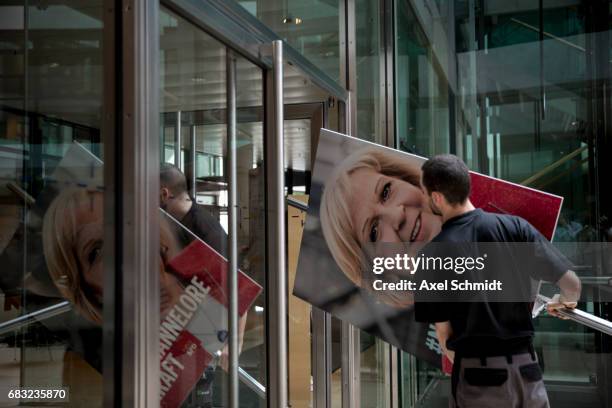 Workers carry a picture of North Rhine-Westphalia SPD lead candidate Hannelore Kraft the day after state elections in North Rhone-Westphalia in which...