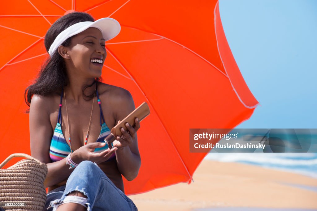 Relaxed woman applying sun protection cream on sunny beach.