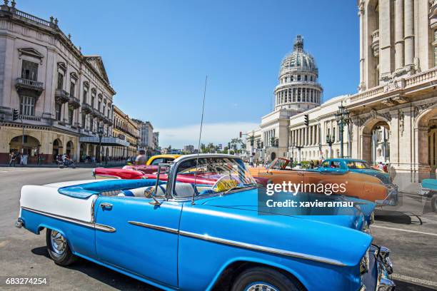 vintage taxis on street in city on sunny day - cuba car stock pictures, royalty-free photos & images