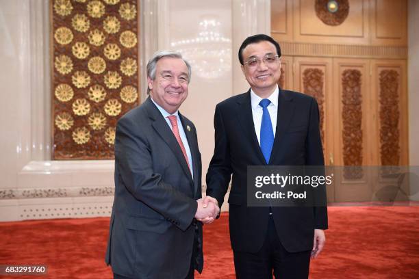 Chinese Premier Li Keqiang poses with United Nations Secretary-General Antonio Guterres for a photo before their meeting on May 15, 2017 at the Great...