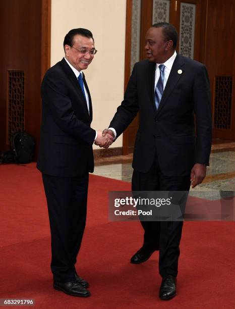 Chinese Premier Li Keqiang and President of Kenya Uhuru Kenyatta shake hands before their meeting on May 15, 2017 at the Great Hall of the People in...