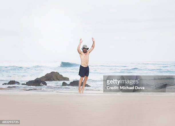 man jumping playing on beach and next to ocean - costa rica beach stock-fotos und bilder