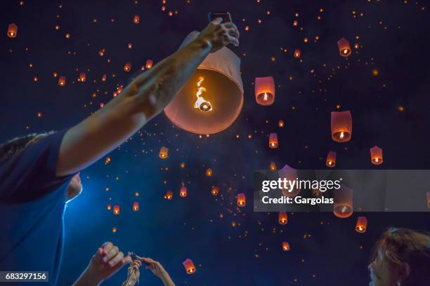 schwimmende asiatische laternen in den himmel von chiang mai, thailand - floating lanterns stock-fotos und bilder