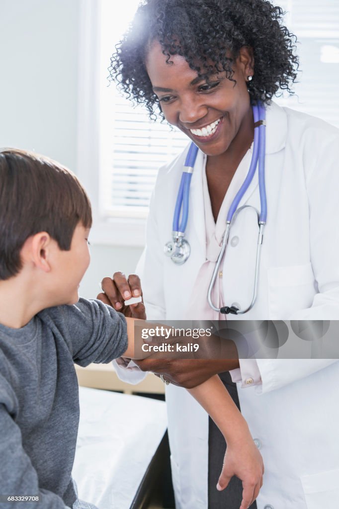 African-American pediatrician treating child