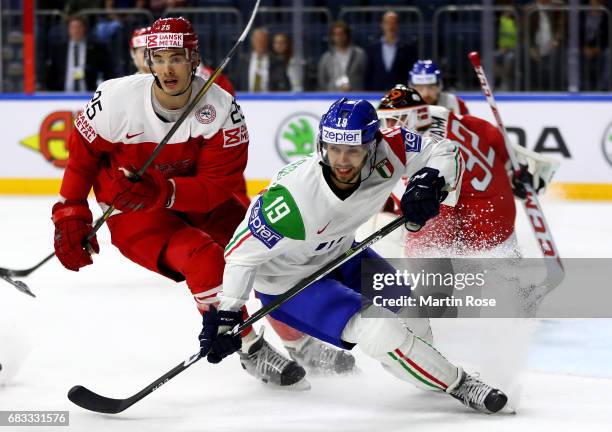 Oliver Lauridsen of Denmark challenges Raphael Andergassen of Italy for the puck during the 2017 IIHF Ice Hockey World Championship game between...