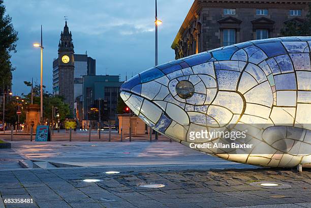 big fish sculpture in belfast illuminated at dusk - animal sculpture stock-fotos und bilder